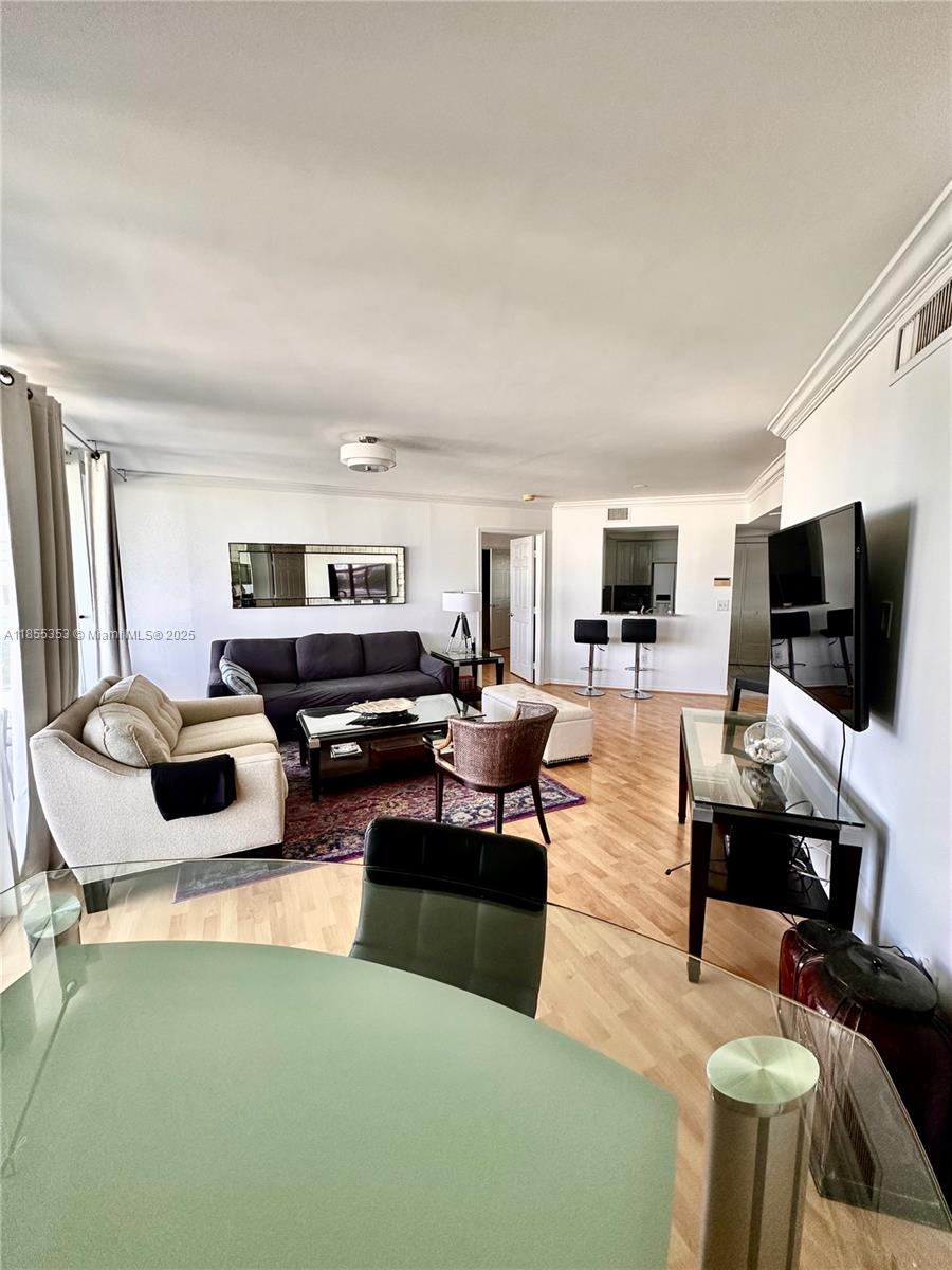 6301 Collins Avenue, Unit 806 Miami Beach, FL 33141 - Photo 3 of 26 a living room with furniture a flat screen tv and kitchen view