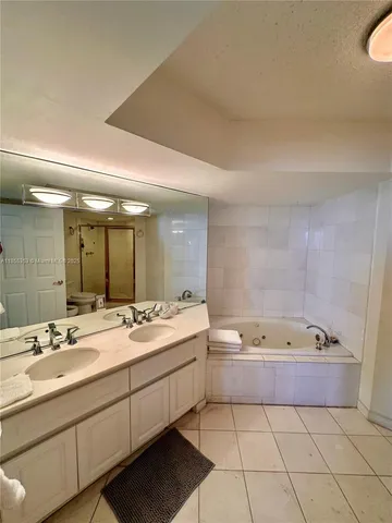 a bathroom with a tub sink and mirror