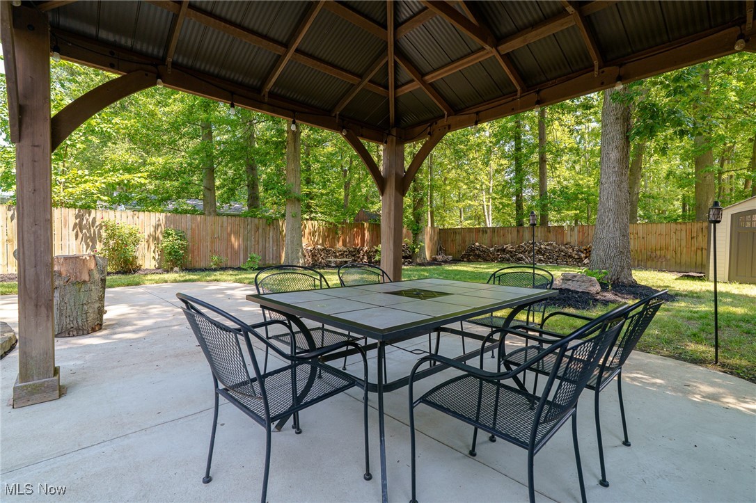 5497 Lear Nagle Road North Ridgeville, OH 44039 - Photo 7 of 33 table under pavilion with large treed yard in background and fully fenced yard.
