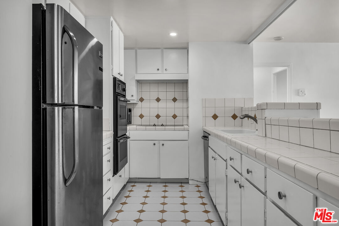 2160 Century Park, Unit 1911 Los Angeles, CA 90067 - Photo 11 of 26 a kitchen with sink a refrigerator and cabinets