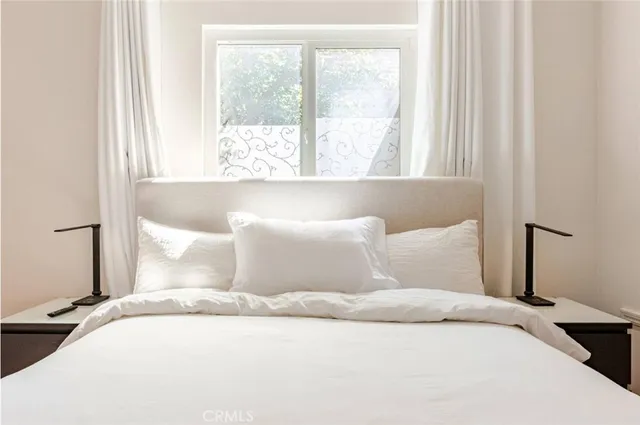 a bed sitting in a bedroom next to a window