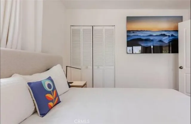 a bedroom with a bed and a painting on the wall