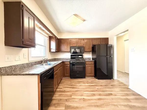 a kitchen with stainless steel appliances granite countertop a refrigerator a stove a sink and a microwave