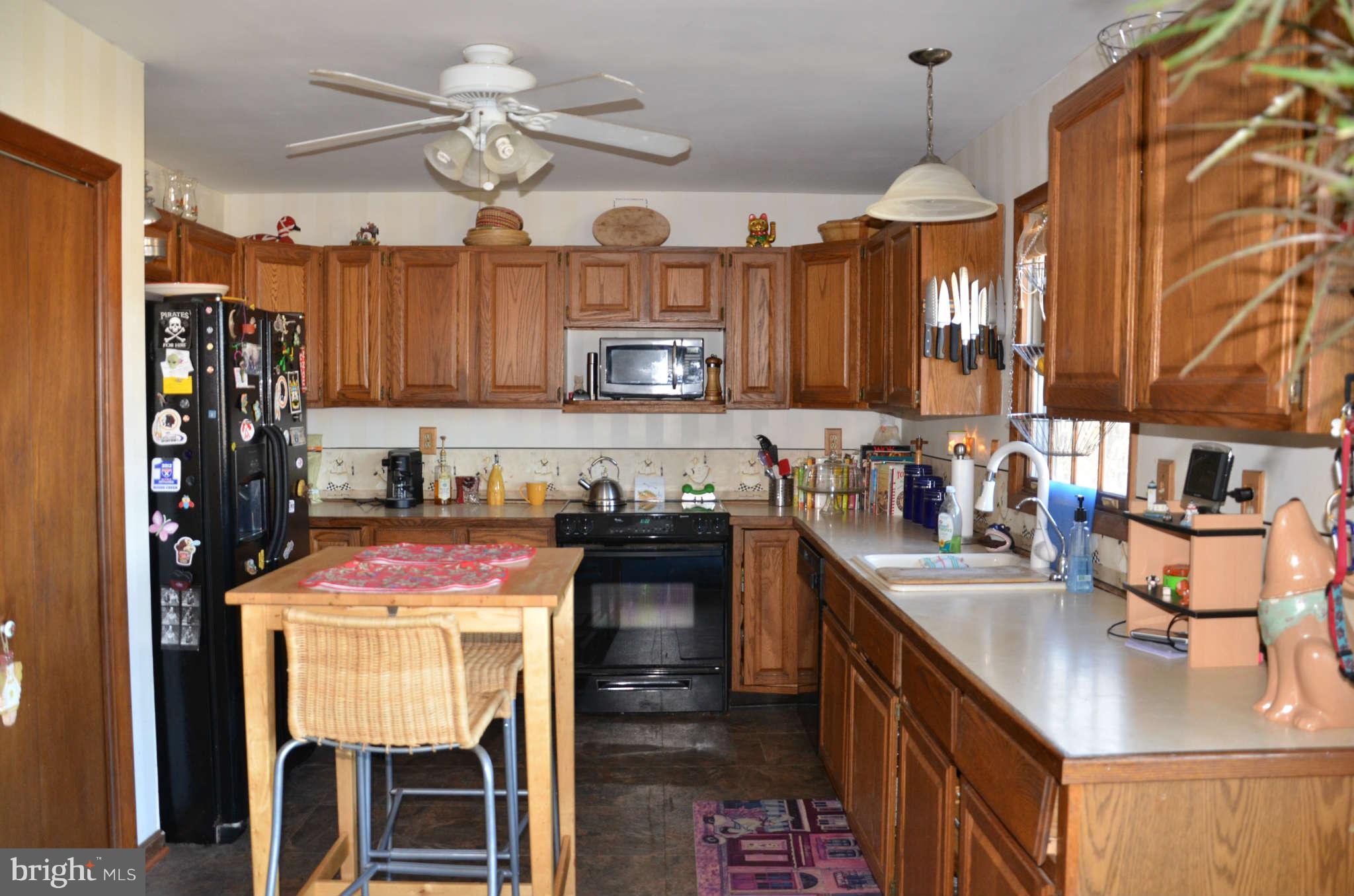 103 Parks Road Chester, MD 21619 - Photo 13 of 25 a kitchen with stainless steel appliances granite countertop a stove top oven a refrigerator a sink and dishwasher with wooden floor