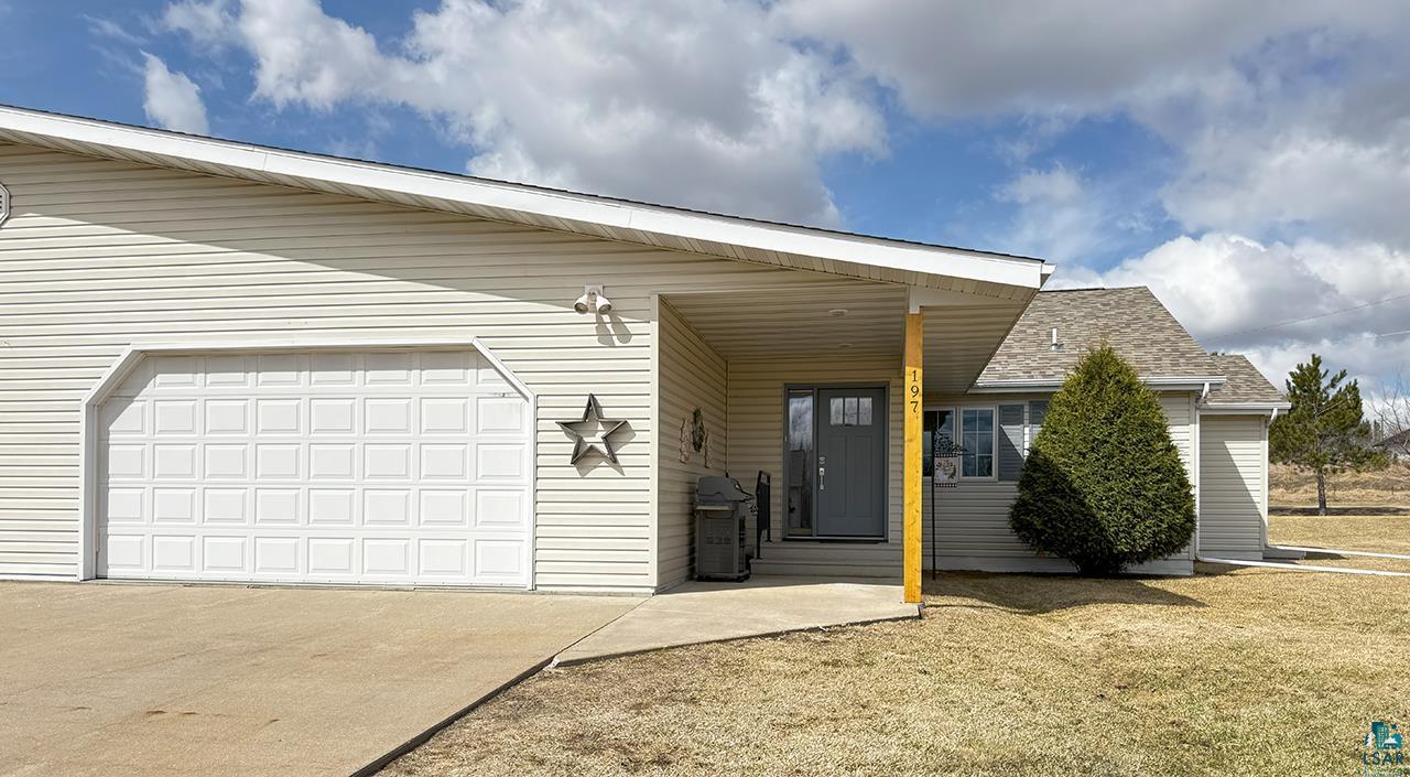 View of front of home featuring driveway, a shingled roof, a front yard, and an attached garage