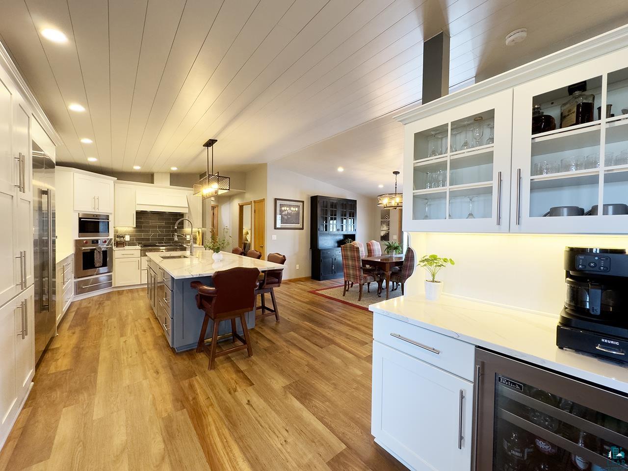 197 Jefferson Street Buhl, MN 55713 - Photo 2 of 31 Kitchen with wine cooler, a kitchen bar, light wood-style floors, appliances with stainless steel finishes, and a sink