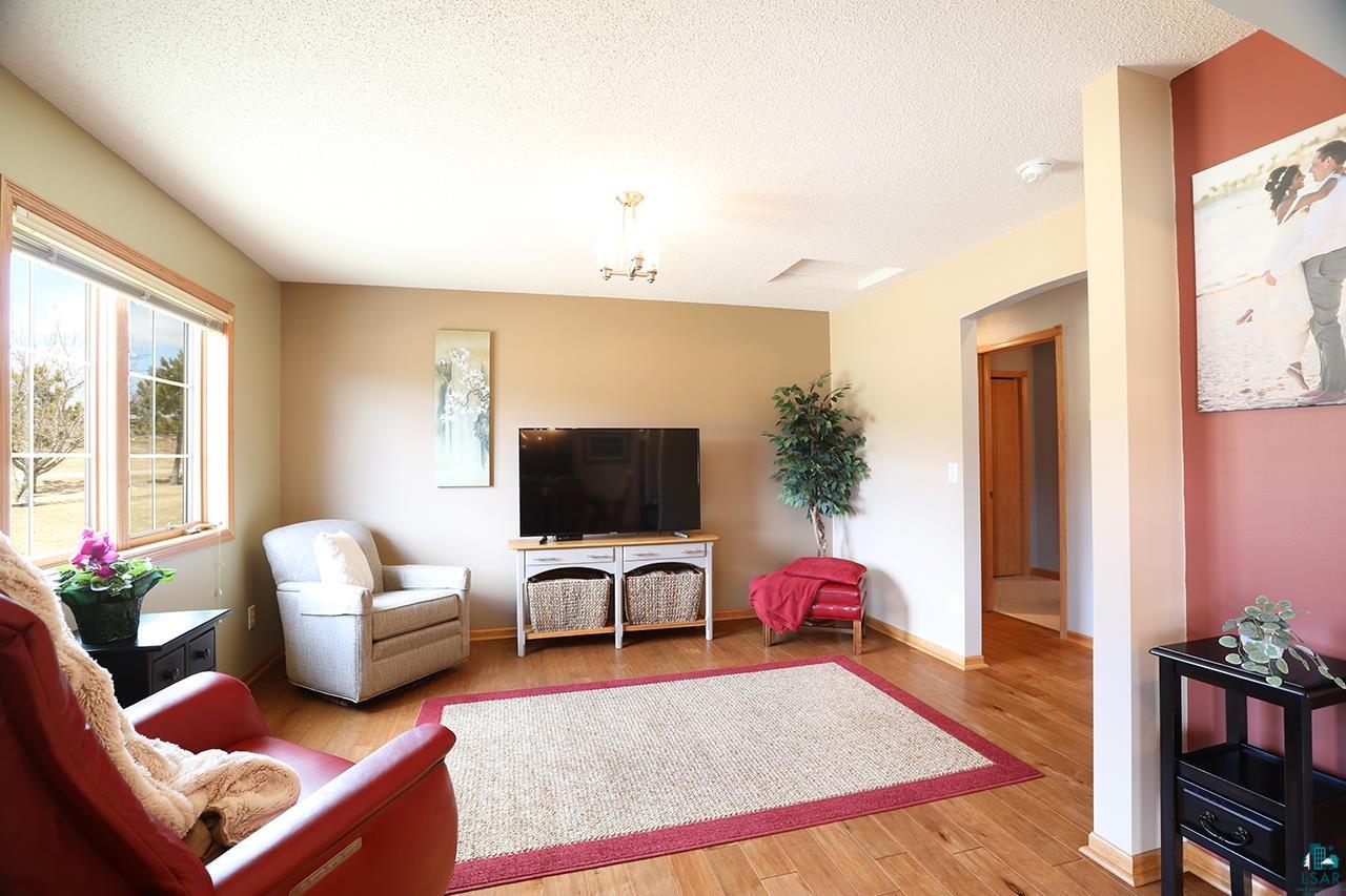 197 Jefferson Street Buhl, MN 55713 - Photo 8 of 31 Living room with wood finished floors, baseboards, and a textured ceiling