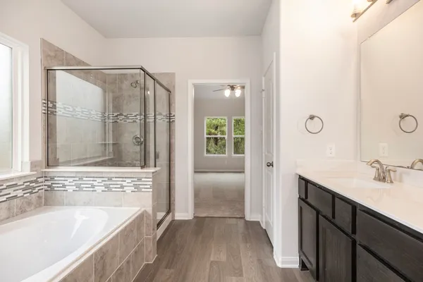 a bathroom with a tub sink and mirror