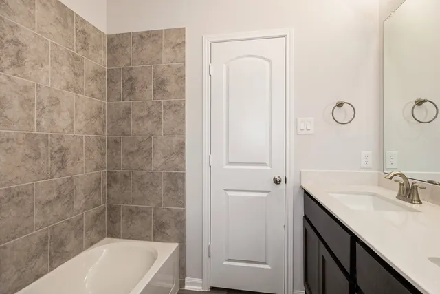 a bathroom with a granite countertop sink a mirror and a bathtub