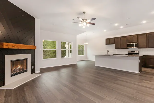 a view of kitchen with granite countertop stove top oven and refrigerator