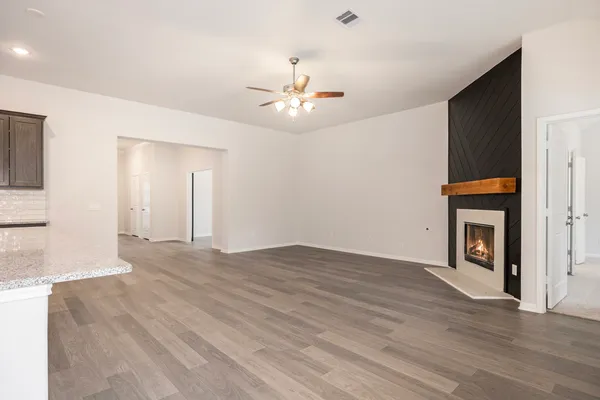 a view of an empty room with window and fireplace