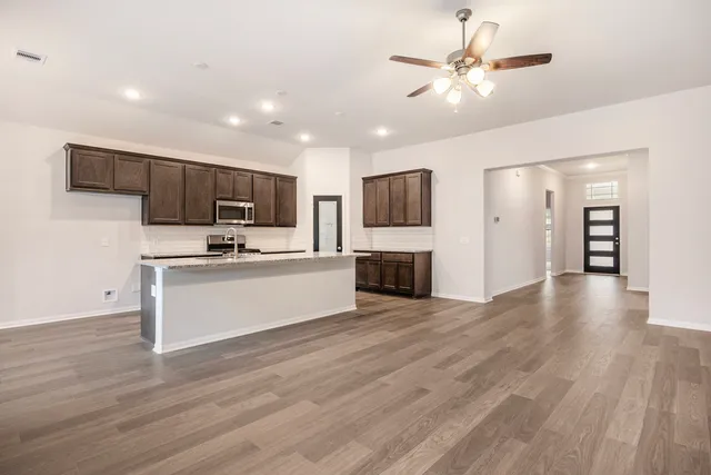 a view of kitchen with microwave stove top oven and cabinets