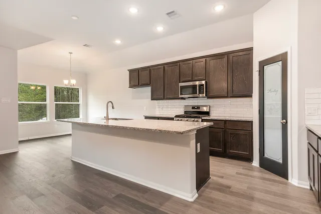 a kitchen with stainless steel appliances granite countertop a stove a sink and a refrigerator