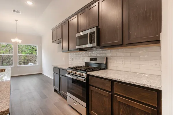 a kitchen with stainless steel appliances granite countertop wooden cabinets stove top oven and sink