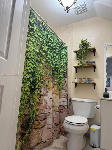 a bathroom with a toilet and a shower curtain
