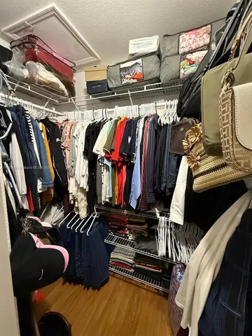a view of walk in closet with clothes and shoes