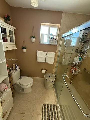 a white toilet sitting next to a bathroom sink and a mirror