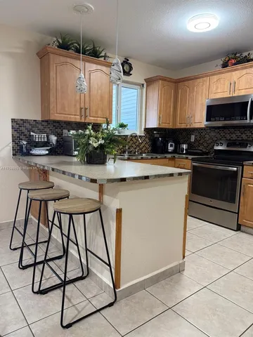 a kitchen with kitchen island granite countertop a stove a sink and a refrigerator