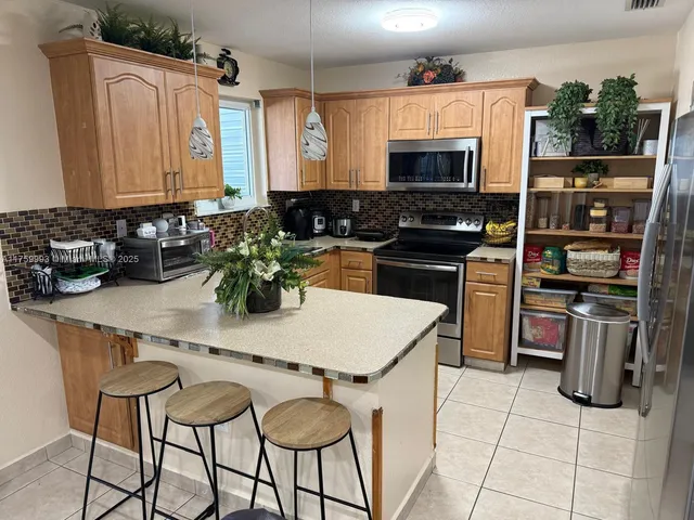 a kitchen with a stove a sink and a microwave