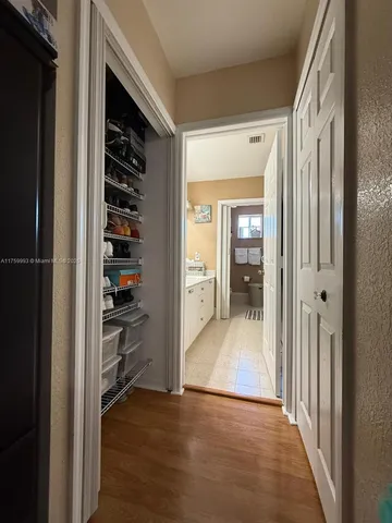 a view of a hallway with wooden floor and windows in a room