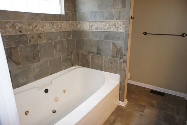 a bath tub sitting next to a white sink and vanity
