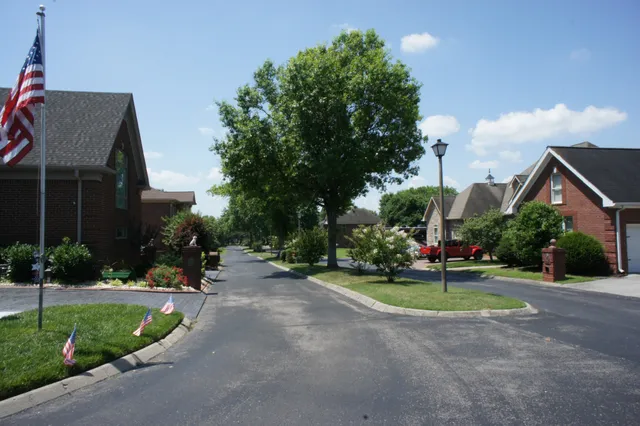 a view of a house with a yard and table and chair under an umbrella