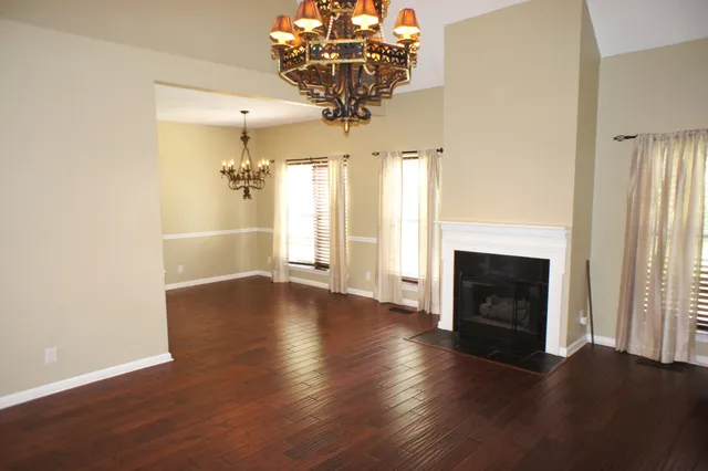 a view of a livingroom with wooden floor a fireplace and window