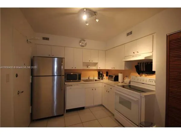 a kitchen with a sink a refrigerator and cabinets