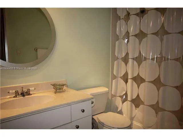 a bathroom with a sink mirror vanity and toilet