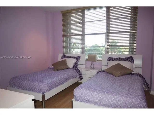 a bedroom with two beds and a large window