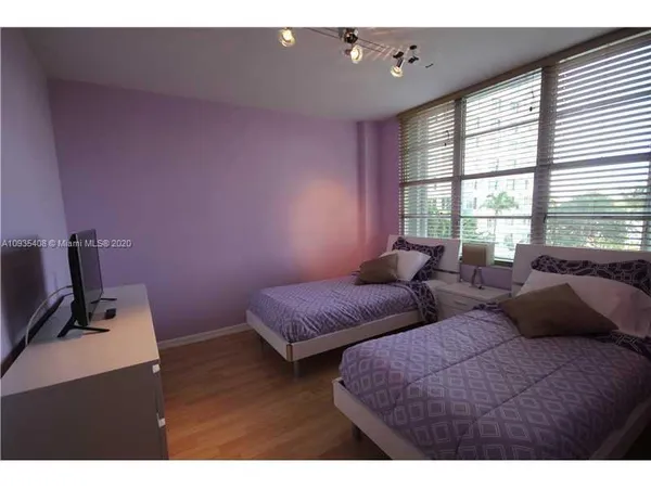 a bedroom with two beds and a window