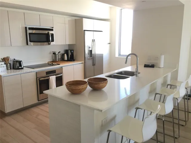 a kitchen with stainless steel appliances granite countertop a sink a stove and a microwave