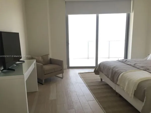 a living room with a bed furniture and a flat screen tv
