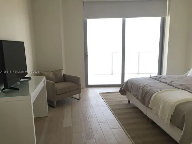 a living room with a bed furniture and a flat screen tv