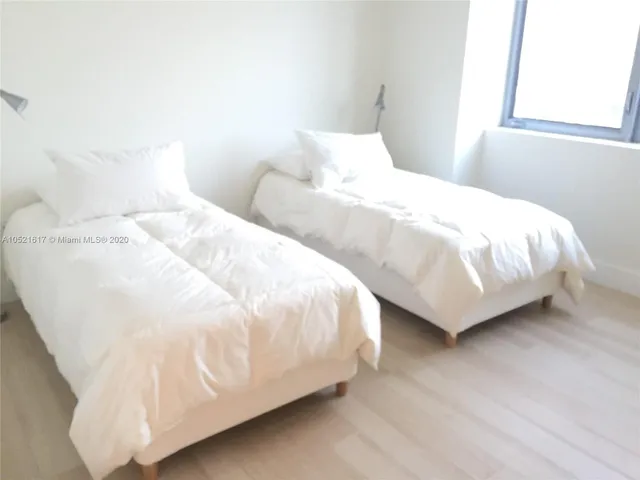 a large white bed in a white room
