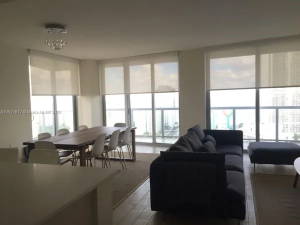 a living room with furniture and large windows