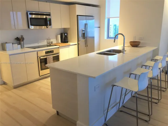 a kitchen with a sink a stove and chairs