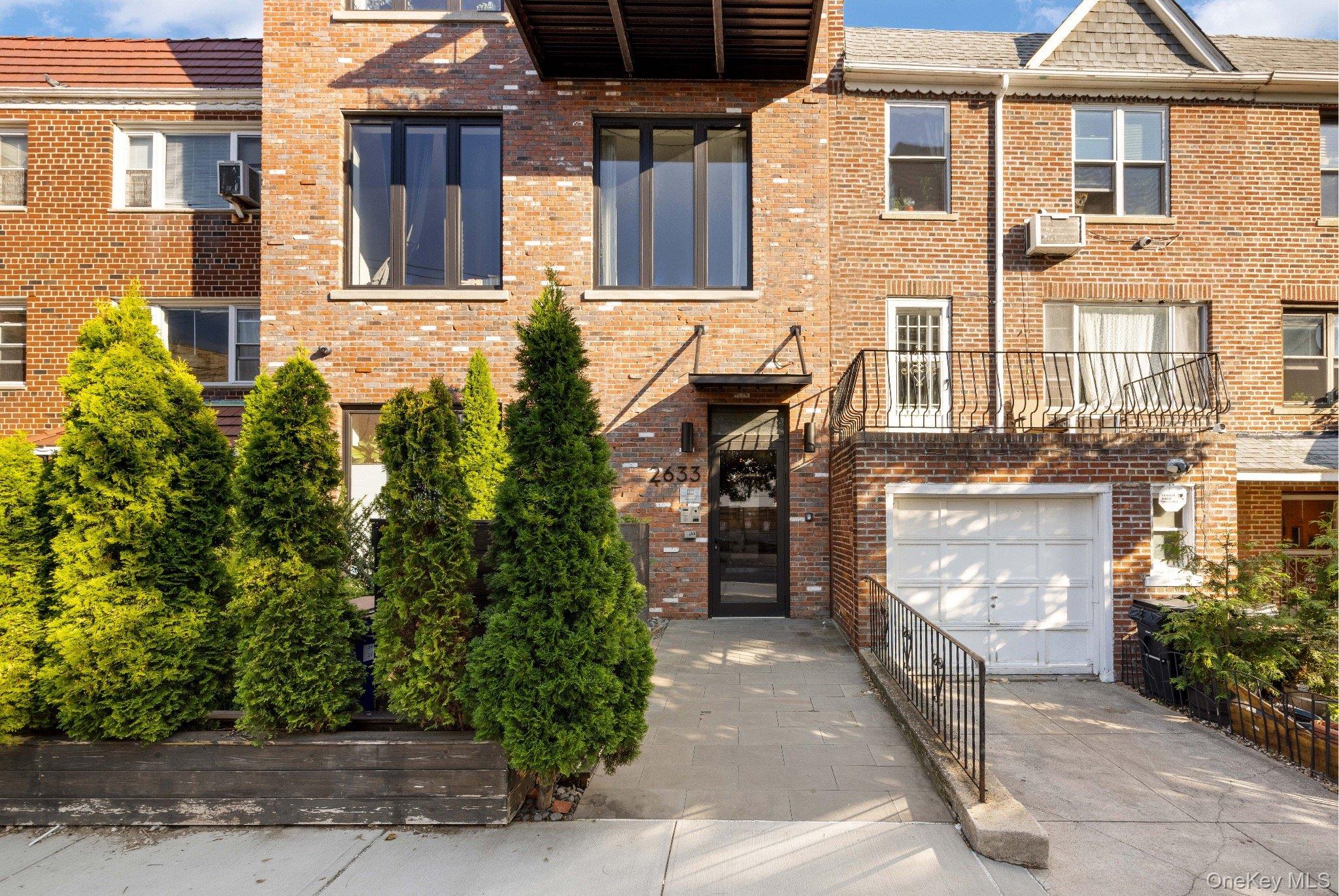 26-33 28th Street, Unit 3B Queens, NY 11102 - Photo 15 of 16 front view of a brick house with a yard