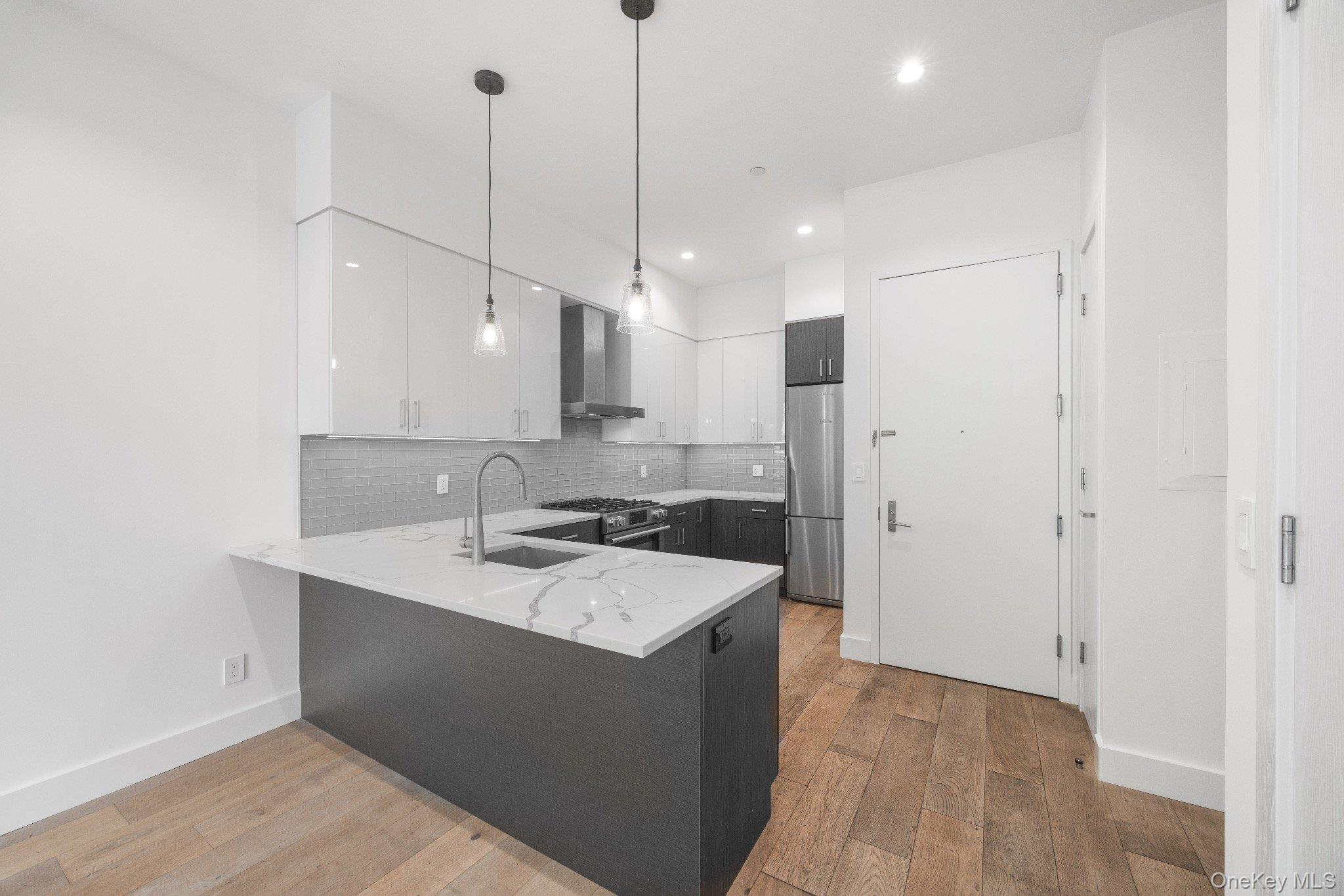 26-33 28th Street, Unit 3B Queens, NY 11102 - Photo 2 of 16 a kitchen with a sink a stove a refrigerator and cabinets