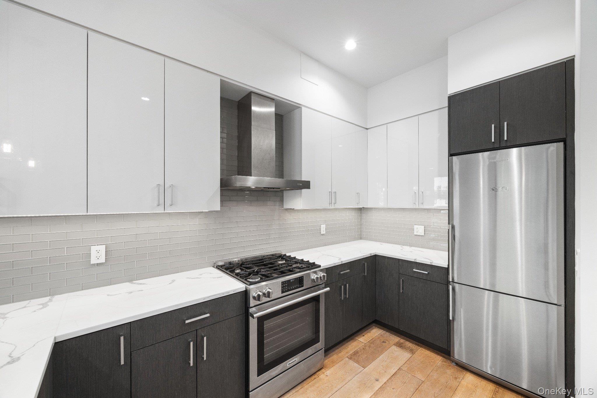 26-33 28th Street, Unit 3B Queens, NY 11102 - Photo 3 of 16 a kitchen with stainless steel appliances granite countertop a refrigerator a sink and a stove
