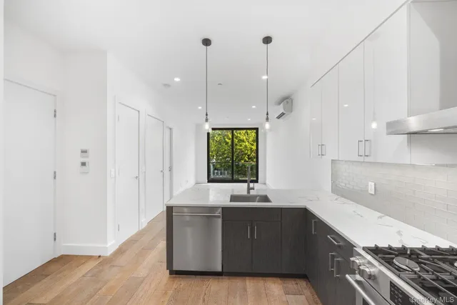 a large kitchen with kitchen island white cabinets and stainless steel appliances
