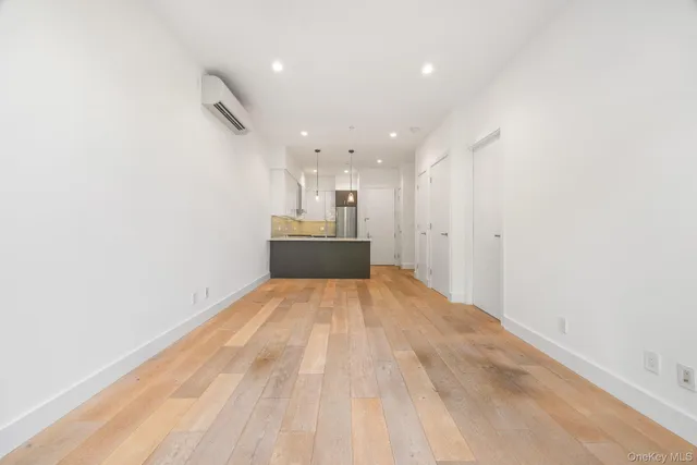 an empty room with kitchen and windows
