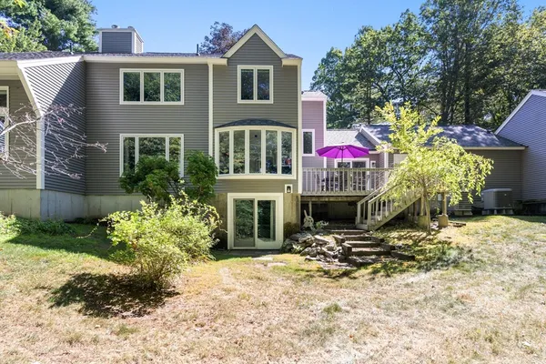 a front view of a house with a yard and potted plants