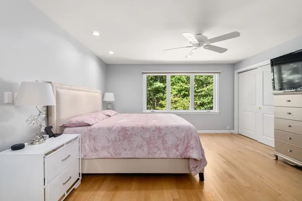 a bedroom with a bed and a flat tv screen on dresser