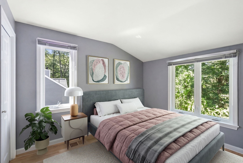 16 Coltsway, Unit 16 Wayland, MA 01778 - Photo 21 of 29 a bedroom with a bed lamp and a large window with potted plants