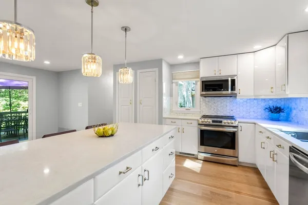 a kitchen with stainless steel appliances granite countertop a sink a stove and cabinets