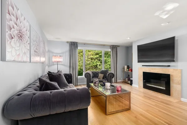 a living room with furniture a flat screen tv and a fireplace
