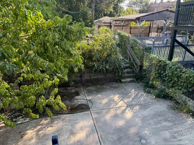 a view of a white house with large windows and a small yard