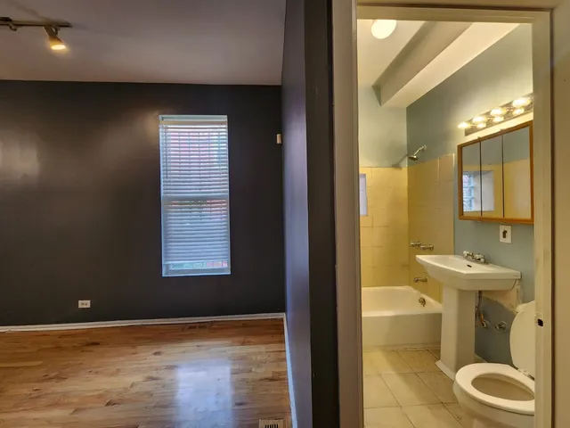 a bathroom with a toilet a sink and mirror