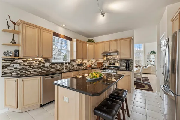 a kitchen with stainless steel appliances granite countertop a refrigerator sink and cabinets